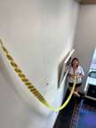 a woman is measuring a wall with tape